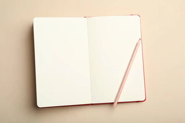 ベージュ地にスタイリッシュなオープンノートと鉛筆 トップビュー — ストック写真