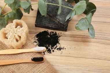 Tahta üzerinde doğal bambu diş fırçaları bulunan düz bir kompozisyon. 