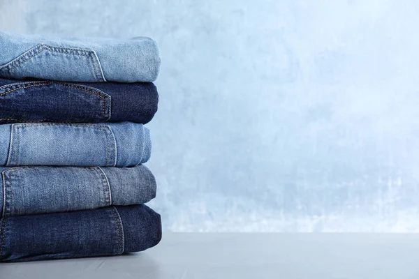 Stack Olika Jeans Ljusbord Mot Blå Bakgrund Plats För Text — Stockfoto