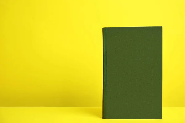 Книга в твердой обложке на жёлтом фоне. Пространство для дизайна — стоковое фото