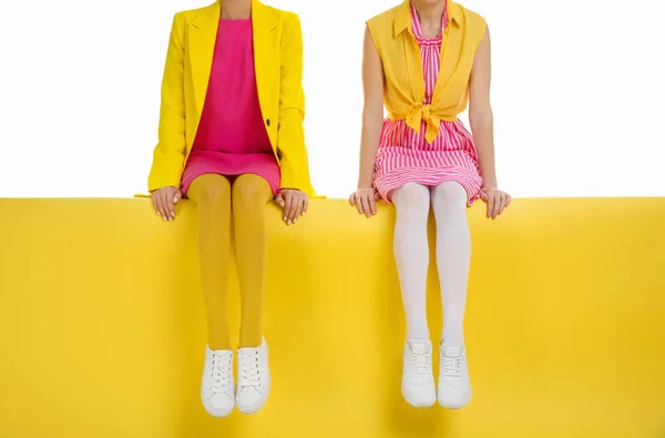 밝은 스타킹을 입고 있는 여자들 색 배경 위에 앉아서 옷을 덮고 있는 여자들 — 스톡 사진
