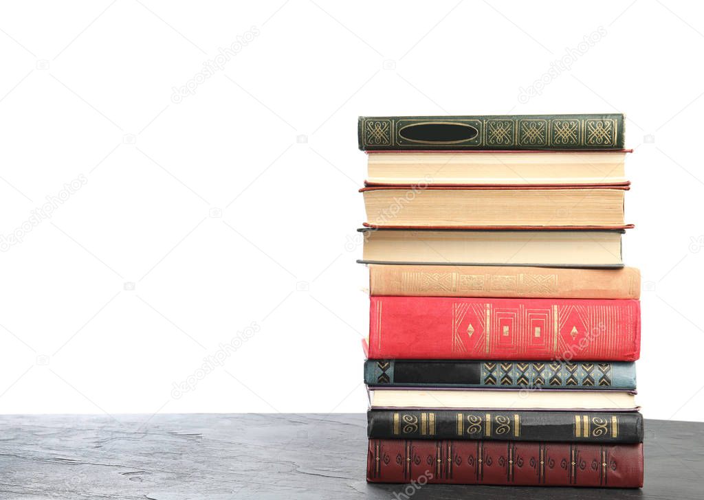 Stack of old vintage books on grey stone table against white bac