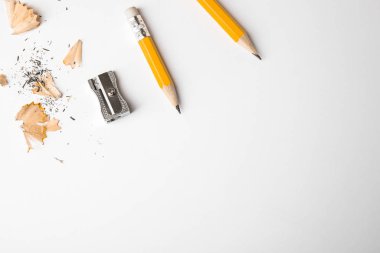 Beyaz arka planda grafit kalemler, talaşlar ve keskinleştirici...