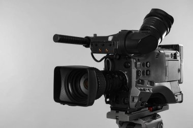 Işık arkaplanındaki modern profesyonel video kamera