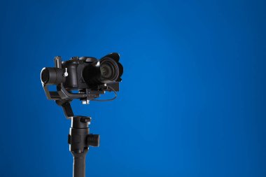 Mavi arka planda modern profesyonel video kamera. Metin için boşluk