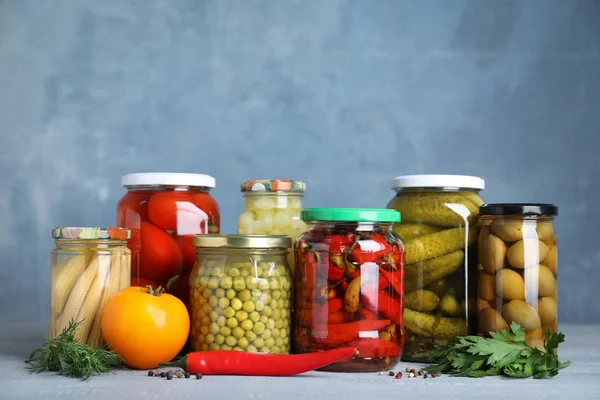 Üvegedények különböző pácolt zöldségekkel az asztalon — Stock Fotó