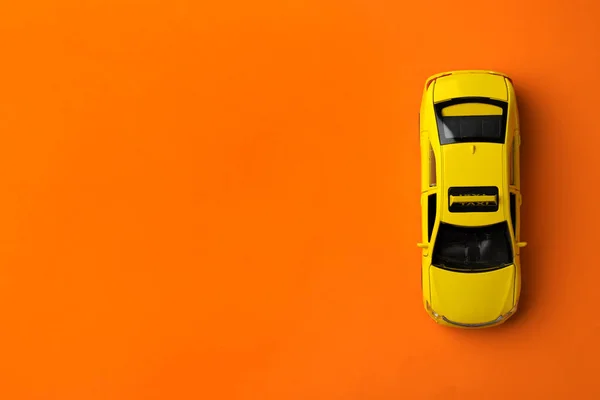 Gelbes Modell Eines Taxifahrzeugs Auf Orangefarbenem Hintergrund Draufsicht Raum Für — Stockfoto