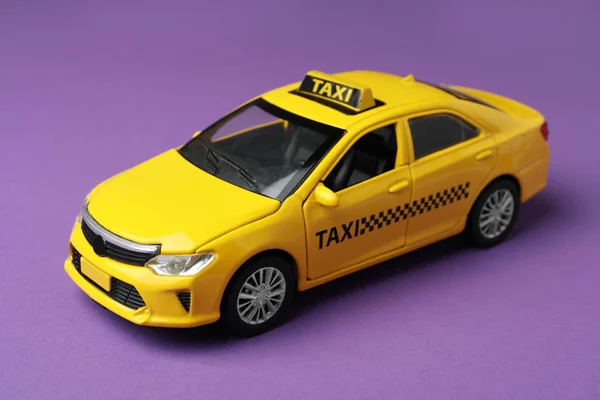 Gelbes Taxi Auto Modell Auf Lila Hintergrund — Stockfoto