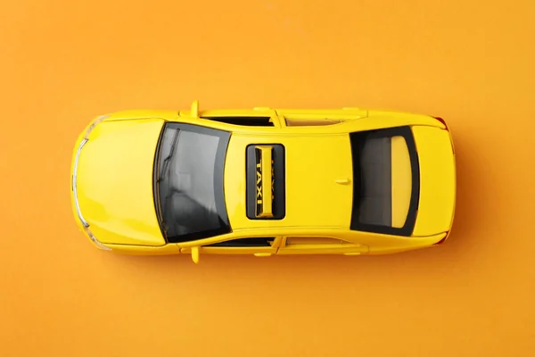 Gelbes Taxi Car Modell Auf Orangefarbenem Hintergrund Draufsicht — Stockfoto