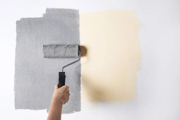 Mujer pintando pared blanca con tinte gris, primer plano — Foto de Stock