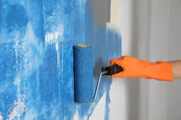 Kvinna målning vit vägg med blå färg, närbild — Stockfoto