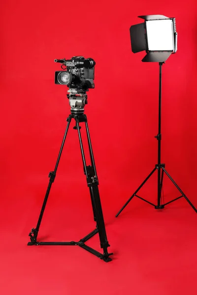Professionelle Videokamera Und Beleuchtungstechnik Auf Rotem Hintergrund — Stockfoto