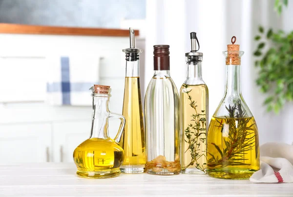Różne rodzaje oleju do gotowania w butelkach na stole w pomieszczeniach — Zdjęcie stockowe