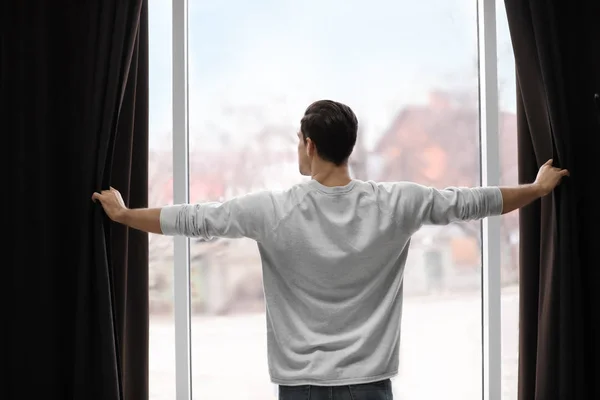Man Opening Window Curtains Home Back View — 스톡 사진