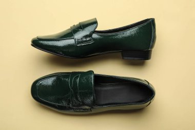 Sarı arka planda şık bir çift kadın ayakkabısı.