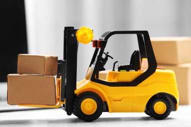 Oyuncak forklift ve dizüstü bilgisayarın yanındaki kutular. Lojistik ve toptan satış kavramı