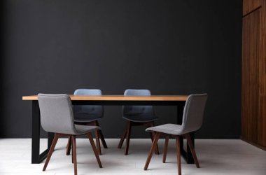 Modern boş tahta masa siyah duvarın yanında.