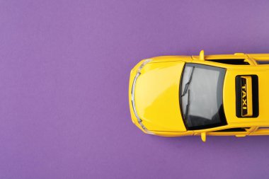 Mor arka planda sarı taksi modeli, üst manzara. Metin için boşluk