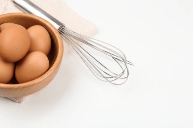 Çiğ yumurta ve çırpı beyaz masada. Pasta yapmak.