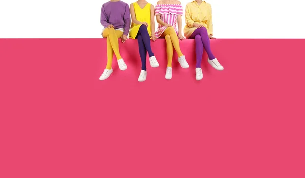 Group of women wearing bright tights and stylish shoes sitting o — Stock Photo, Image