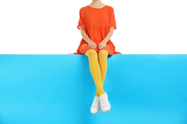 Kobieta w żółtych rajstopach i stylowe buty siedzi na kolorze b — Zdjęcie stockowe