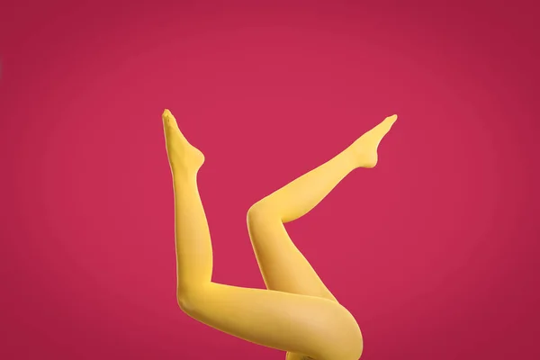 Kobieta Ubrana Żółte Rajstopy Karmazynowym Tle Zbliżenie Nóg — Zdjęcie stockowe