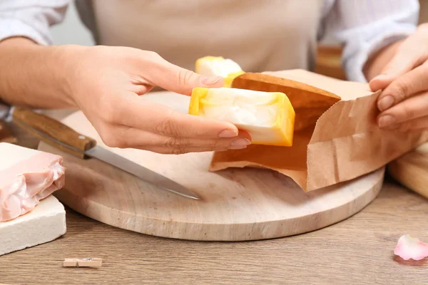 Mujer Poniendo Jabón Natural Hecho Mano Bolsa Papel Mesa Madera —  Fotos de Stock