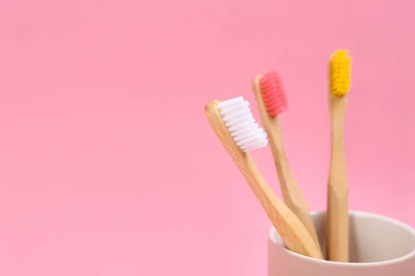 Toothbrushes made of bamboo in holder on pink background. Space — Stock Photo, Image