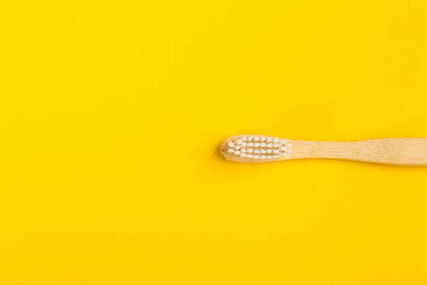 Toothbrush made of bamboo on yellow background, top view. Space — Stock Photo, Image