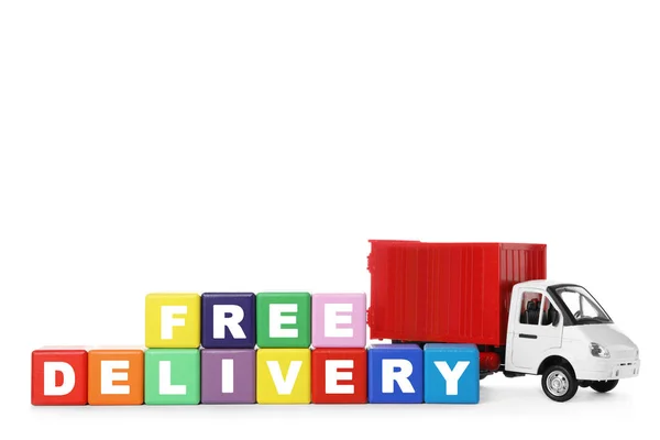 Іграшкова вантажівка та кубики зі словами FREE DELIVERY ізольовані на білому . — стокове фото