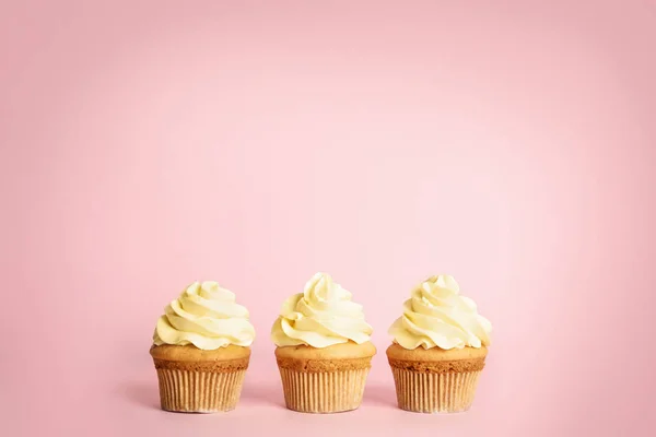 Verjaardags cupcakes versierd met crème op roze achtergrond — Stockfoto