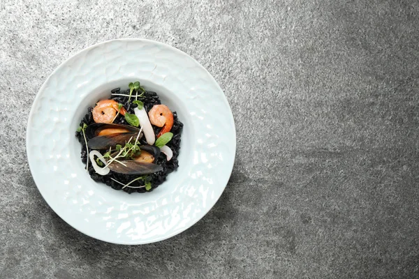 Heerlijke Zwarte Risotto Met Zeevruchten Grijze Tafel Bovenaanzicht Ruimte Voor — Stockfoto