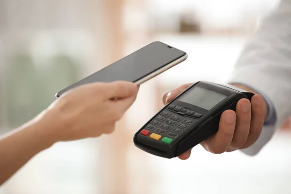 Cliente que usa terminal para pago sin contacto con teléfono inteligente — Foto de Stock