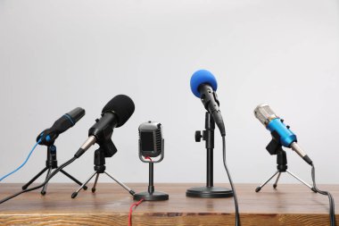 Set of different microphones on wooden table. Journalist's equip clipart