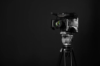 Siyah arka planda modern profesyonel video kamera. Metin için boşluk