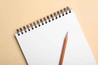Bej arkaplan, üst görünüm üzerinde defter ve kalem aç