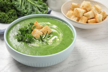 Beyaz ahşap masada lezzetli lahana çorbası, yakın plan.