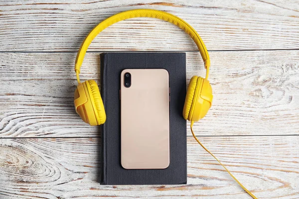 Livro, fones de ouvido modernos e smartphone na mesa de madeira branca, fl — Fotografia de Stock