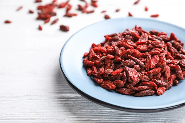 Bayas de goji secas sobre mesa de madera blanca, primer plano — Foto de Stock