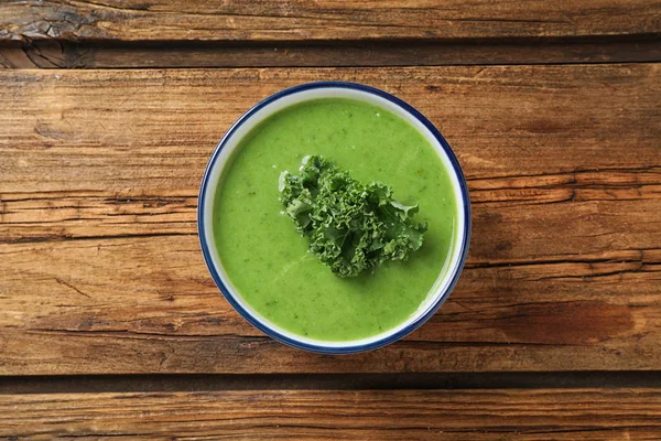 Soupe de chou frisé savoureuse sur table en bois, vue sur le dessus — Photo