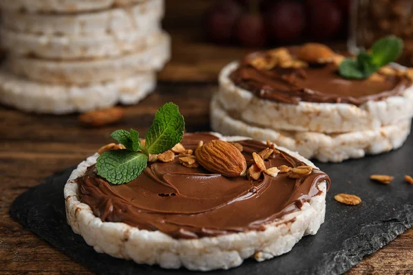 Bolos Arroz Soprado Com Propagação Chocolate Nozes Hortelã Mesa Madeira — Fotografia de Stock