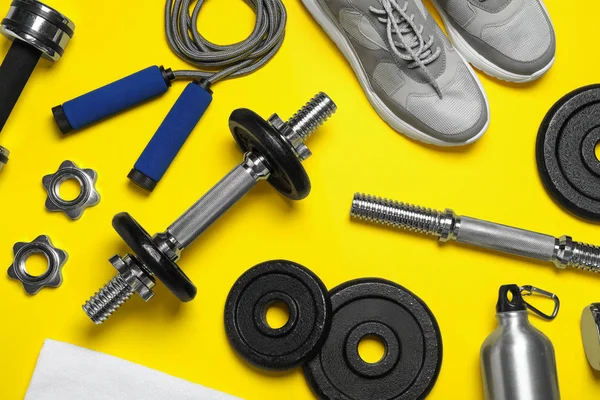 Gym equipment on yellow background, flat lay — 스톡 사진