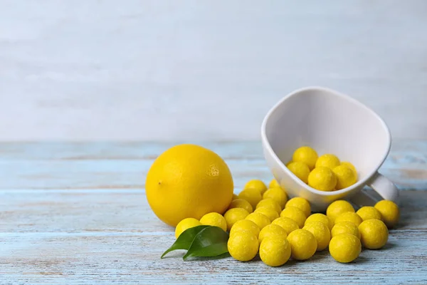 Verse citroen en smakelijk kauwgom op lichtblauwe houten tafel — Stockfoto