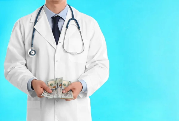 Doctor with bribe on light blue background, closeup. Corruption — 스톡 사진