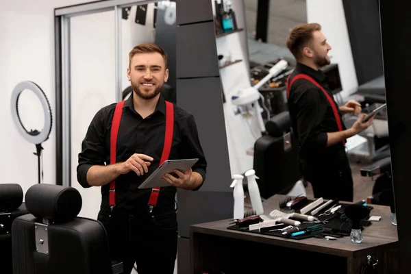 Jeune propriétaire d'entreprise avec tablette dans le salon de coiffure — Photo