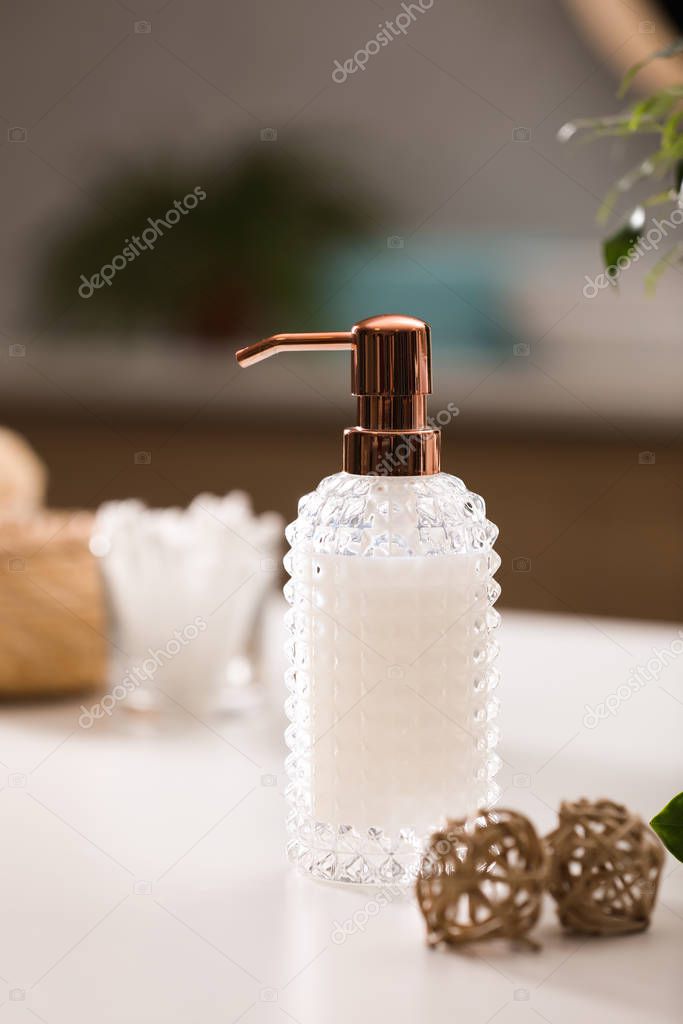 Stylish soap dispenser on white table indoors