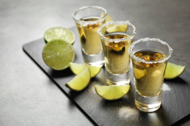 Meksika tekilası. Gri masada tuz ve limon dilimleri.