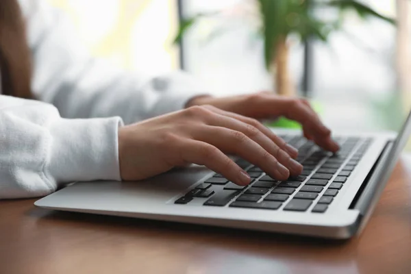 Young blogger working with laptop in cafe, closeup