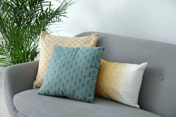 Different soft pillows on sofa in living room — 스톡 사진