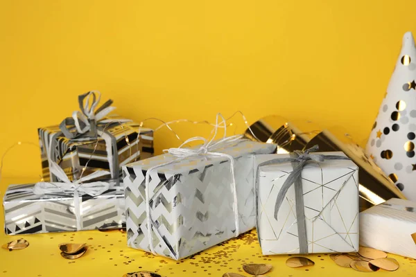 Gift boxes and birthday decor on yellow background